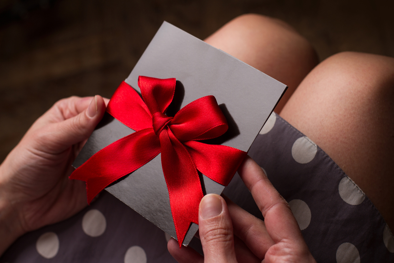 cartes de voeux et ruban rouge dans les mains d'une femme